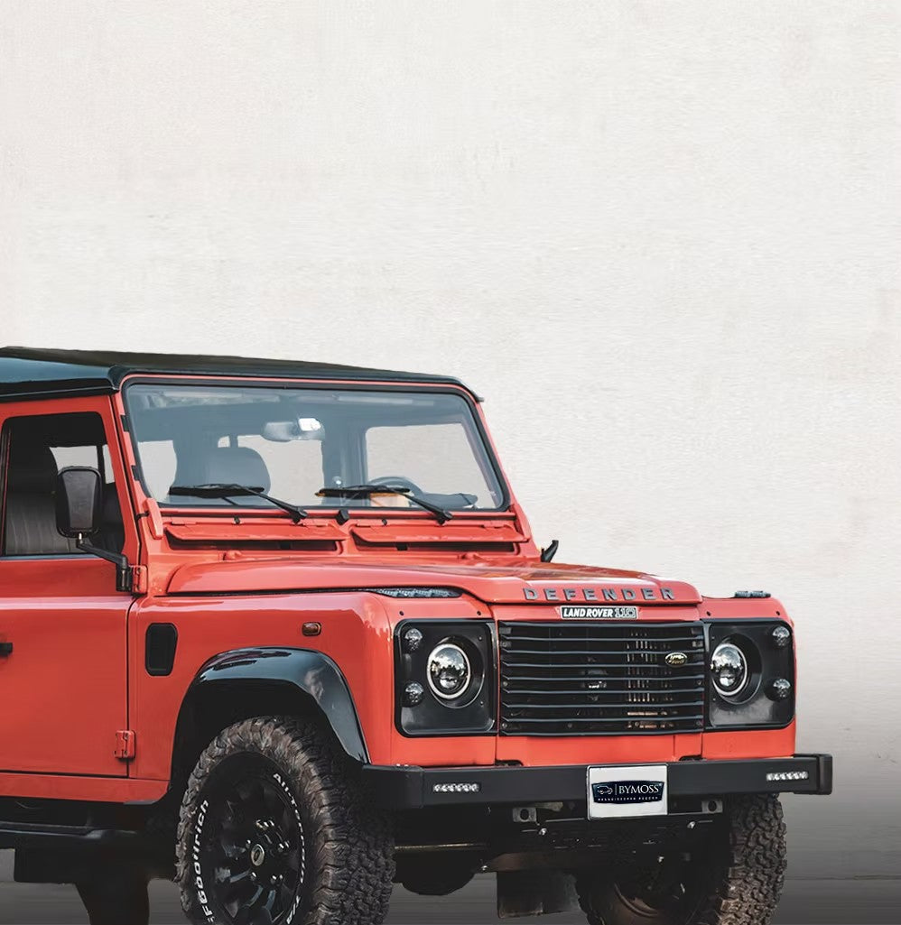Land Rover Defender électrique Bymoss — orange avec badge Reengineered Reborn